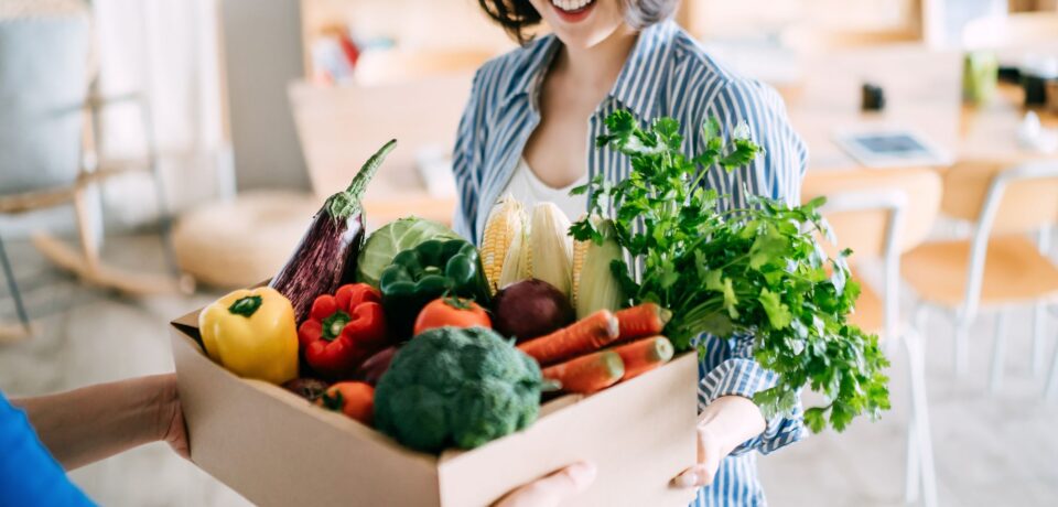 cheerful-young-asian-woman-receiving-a-box-full-of-royalty-free-image-1686340421